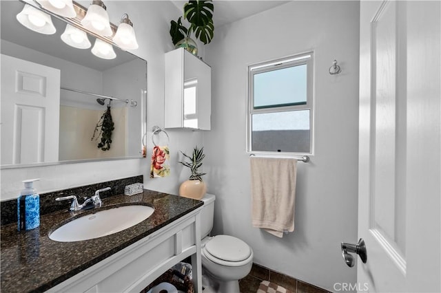 bathroom with vanity, toilet, and a shower