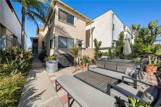 back of property with an outdoor living space and a patio