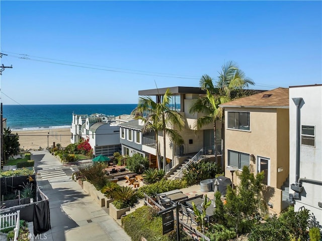 view of property with a water view and a view of the beach