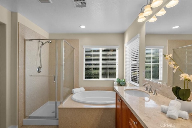 bathroom with shower with separate bathtub and vanity