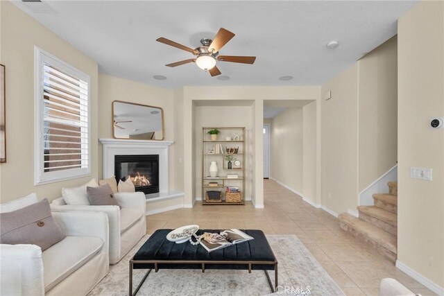 tiled living room featuring ceiling fan and built in features