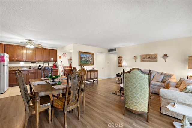 24055 Paseo Del Lago Unit 103, Laguna Woods, CA 92637 - dining space with visible vents, ceiling fan, light wood-type flooring, and a textured ceiling