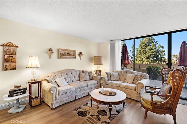 living room featuring a textured ceiling, expansive windows, and hardwood / wood-style floors