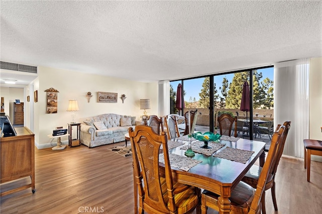 dining area featuring light hardwood / wood-style flooring and a textured ceiling