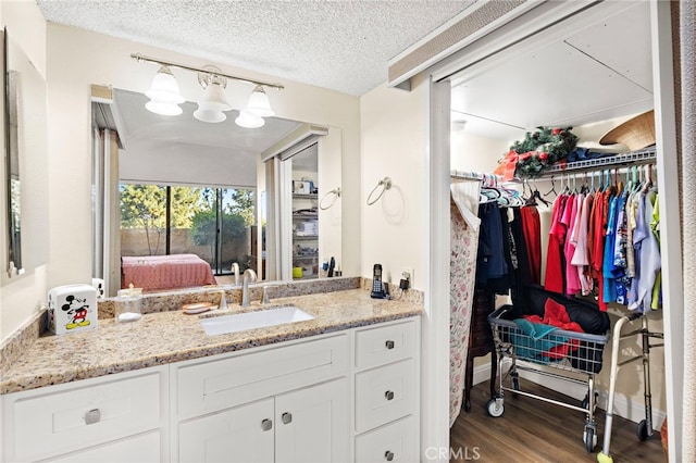 bathroom featuring hardwood / wood-style flooring, a textured ceiling, and vanity