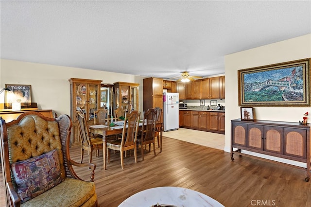 24055 Paseo Del Lago Unit 103, Laguna Woods, CA 92637 - dining room featuring a ceiling fan, light wood-style floors, and a textured ceiling