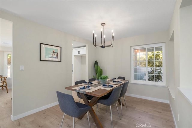 dining room with an inviting chandelier, plenty of natural light, and light hardwood / wood-style flooring