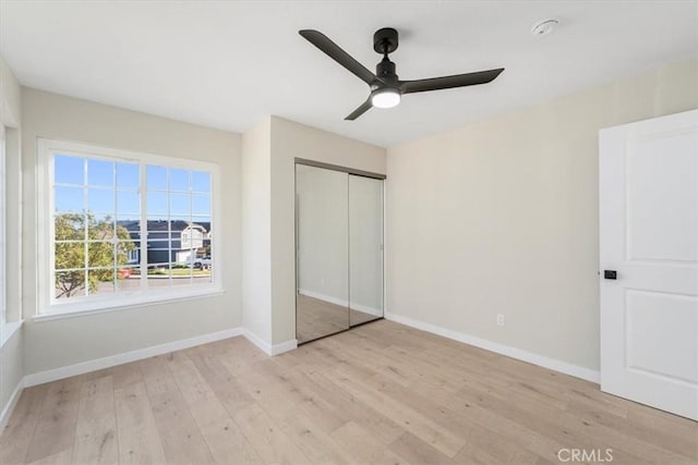 unfurnished bedroom featuring a closet, ceiling fan, and light hardwood / wood-style flooring