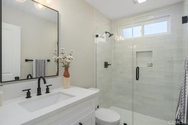 bathroom featuring walk in shower, vanity, and toilet