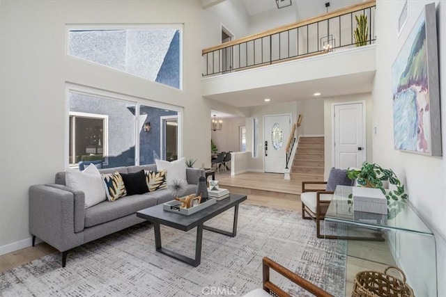 living room with a towering ceiling and light wood-type flooring