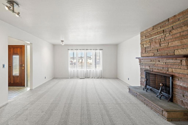 unfurnished living room with a brick fireplace and light carpet