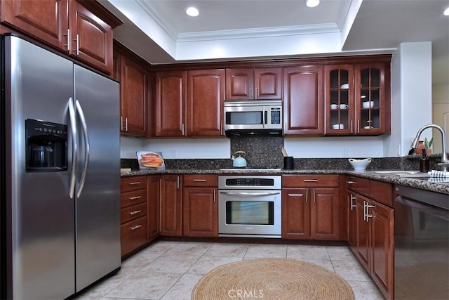 kitchen with dark stone countertops, sink, a tray ceiling, ornamental molding, and black appliances