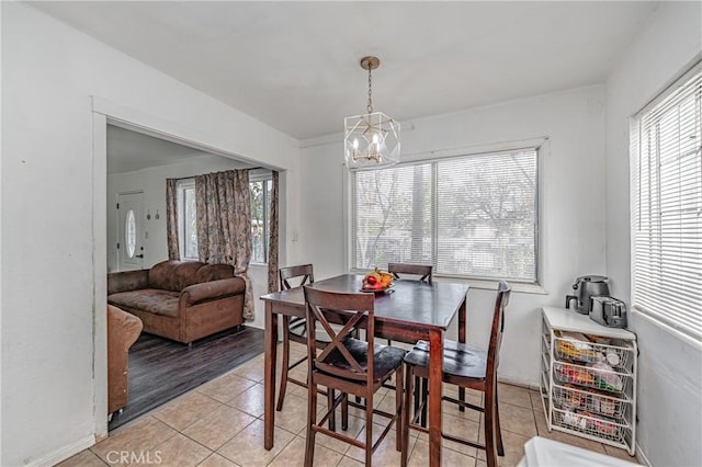 dining space with a chandelier, light tile patterned flooring, and plenty of natural light