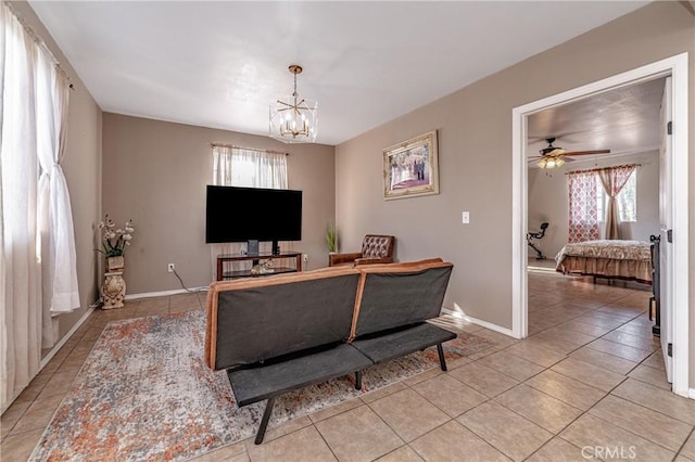 living room featuring ceiling fan with notable chandelier and light tile patterned floors