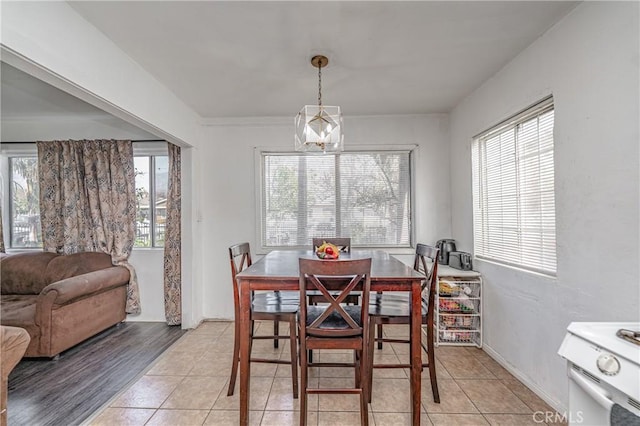 tiled dining space featuring an inviting chandelier and plenty of natural light