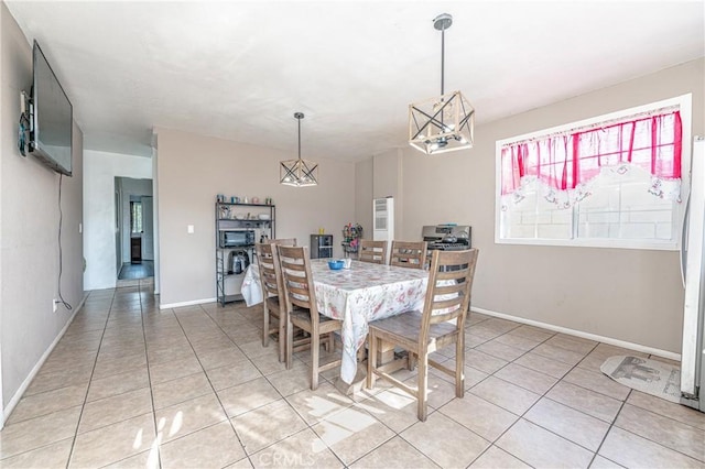 tiled dining room featuring an inviting chandelier