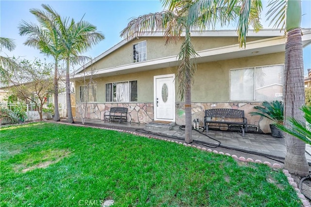 rear view of property featuring a yard and a patio area