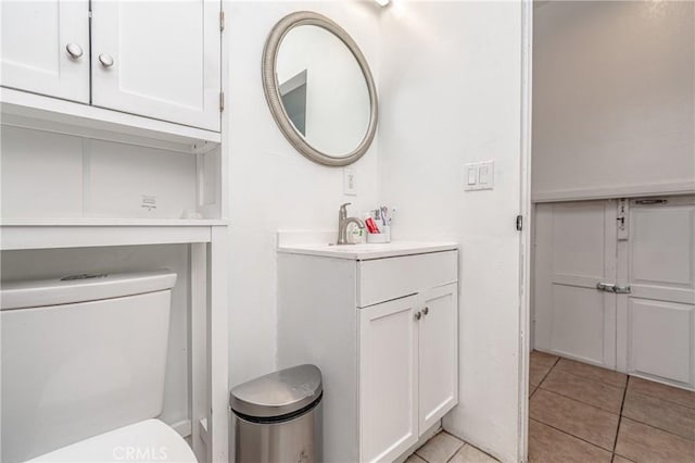 bathroom featuring toilet, tile patterned flooring, and vanity