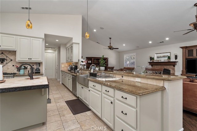 kitchen featuring vaulted ceiling, decorative backsplash, pendant lighting, and white cabinetry