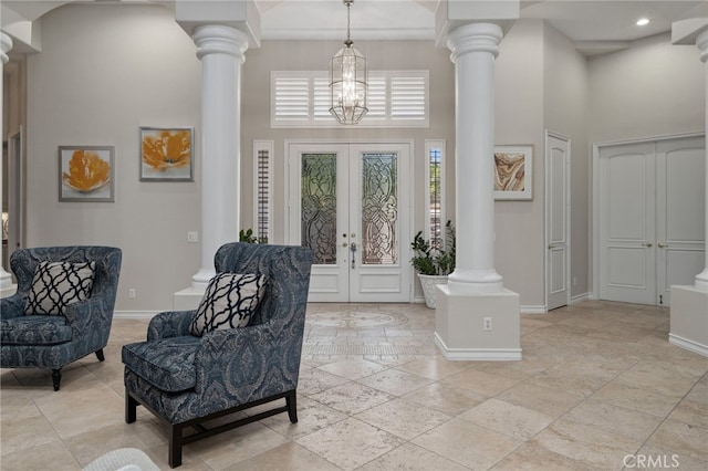 foyer entrance featuring a high ceiling, french doors, and a notable chandelier