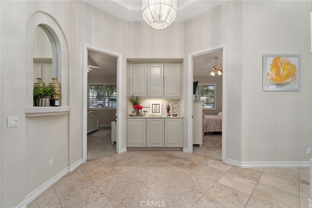 kitchen with ceiling fan with notable chandelier and light carpet