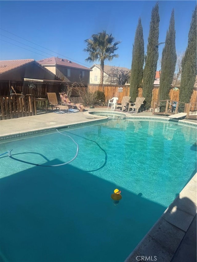 view of swimming pool with an in ground hot tub