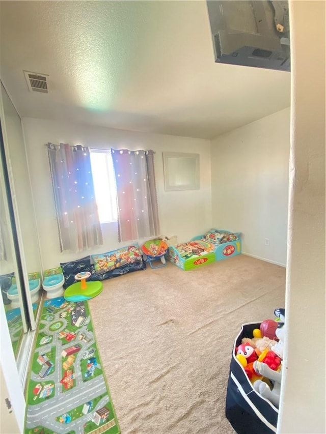 rec room featuring a textured ceiling and carpet