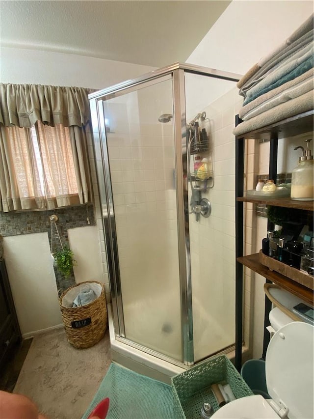 bathroom featuring toilet and an enclosed shower