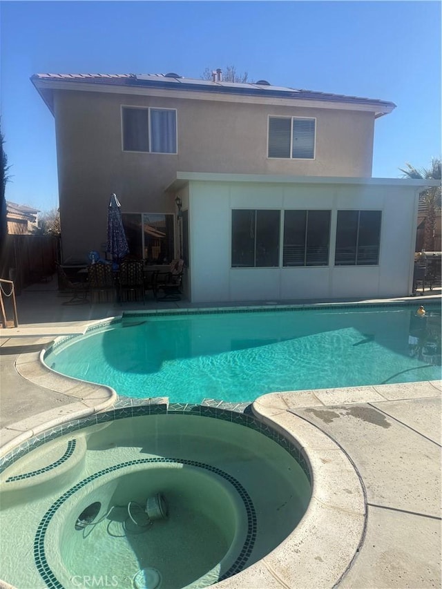 view of pool with an in ground hot tub