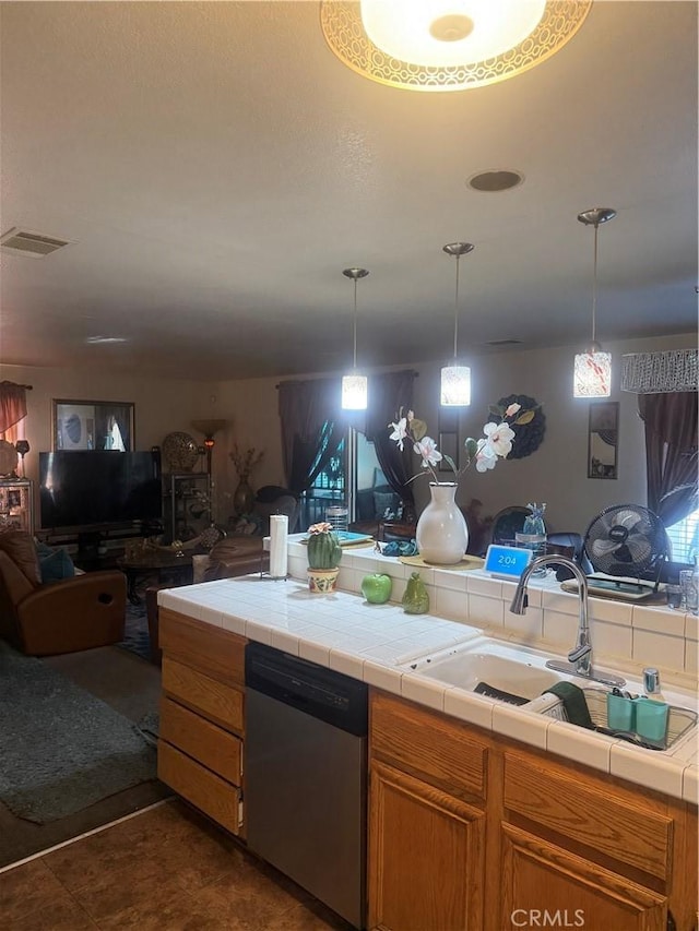 kitchen featuring sink, dishwasher, tile counters, dark tile patterned floors, and pendant lighting