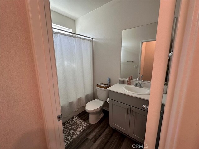 full bathroom featuring hardwood / wood-style flooring, vanity, toilet, and shower / bath combo with shower curtain