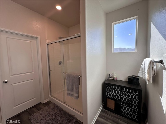 bathroom featuring hardwood / wood-style flooring and a shower with door