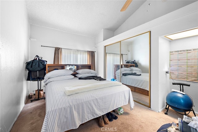 bedroom with lofted ceiling, carpet flooring, a closet, and ceiling fan