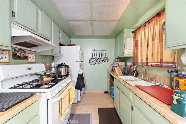 kitchen featuring sink, green cabinetry, white range with gas cooktop, and light hardwood / wood-style floors