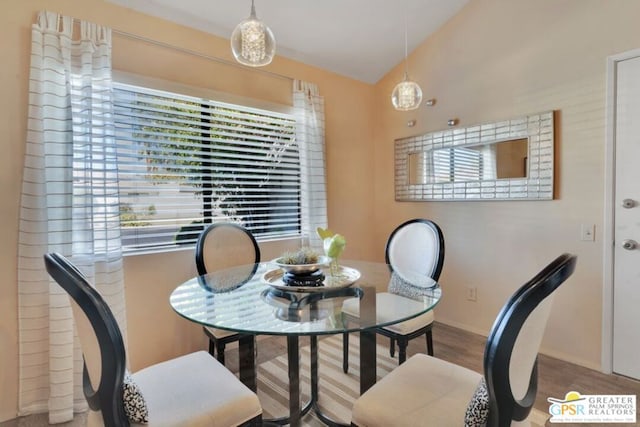 dining space featuring lofted ceiling and hardwood / wood-style flooring