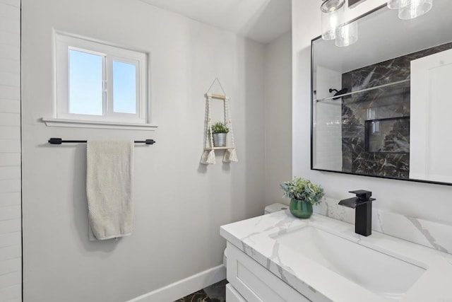 bathroom featuring tiled shower and vanity