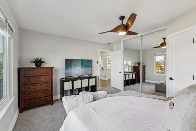 carpeted bedroom featuring ceiling fan and a closet