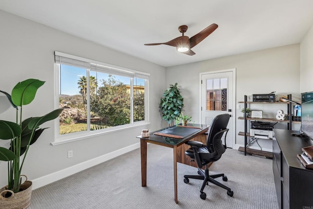 carpeted home office with ceiling fan and plenty of natural light