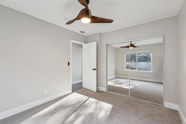 unfurnished bedroom featuring light colored carpet, ceiling fan, and a closet