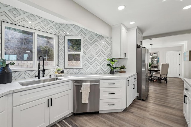 kitchen featuring sink, appliances with stainless steel finishes, tasteful backsplash, and white cabinetry