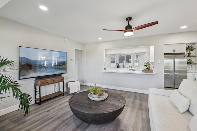 living room featuring ceiling fan and hardwood / wood-style floors