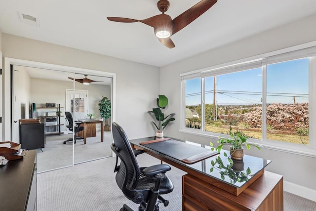 carpeted home office featuring ceiling fan