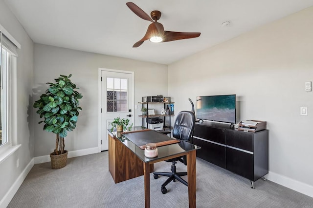 carpeted office space featuring ceiling fan