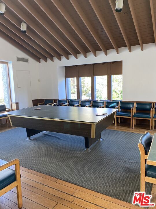 game room with high vaulted ceiling, pool table, wood-type flooring, and beamed ceiling