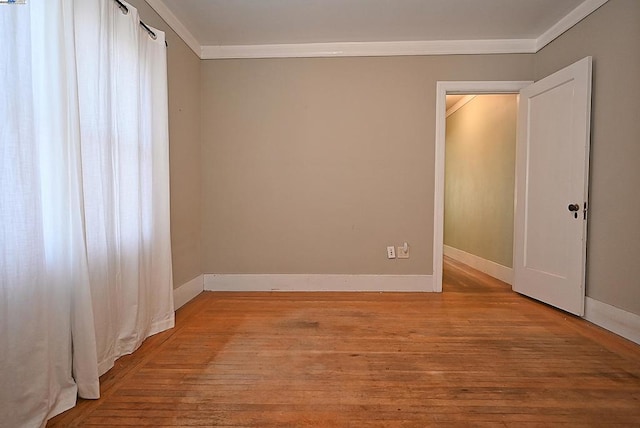 empty room with light wood-type flooring and ornamental molding