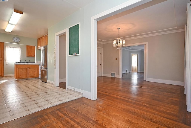 interior space with ornamental molding, light wood-type flooring, and a chandelier