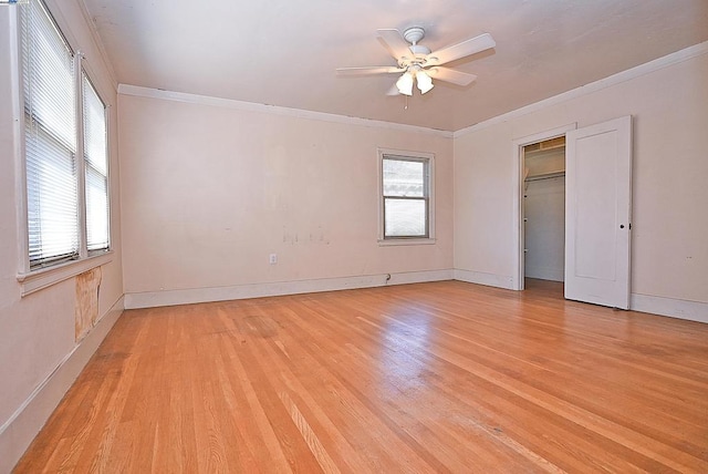 unfurnished bedroom with ornamental molding, ceiling fan, light hardwood / wood-style flooring, and a closet