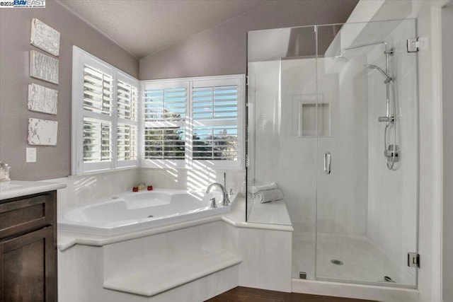 bathroom with independent shower and bath, vanity, lofted ceiling, and a wealth of natural light