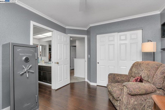 sitting room with crown molding and dark wood-type flooring