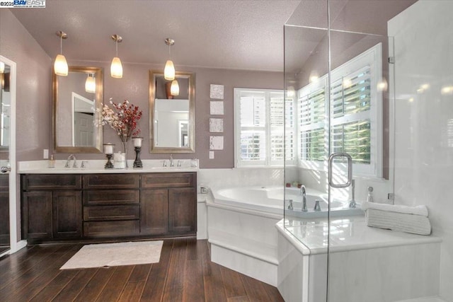 bathroom featuring vanity, hardwood / wood-style floors, independent shower and bath, and a textured ceiling